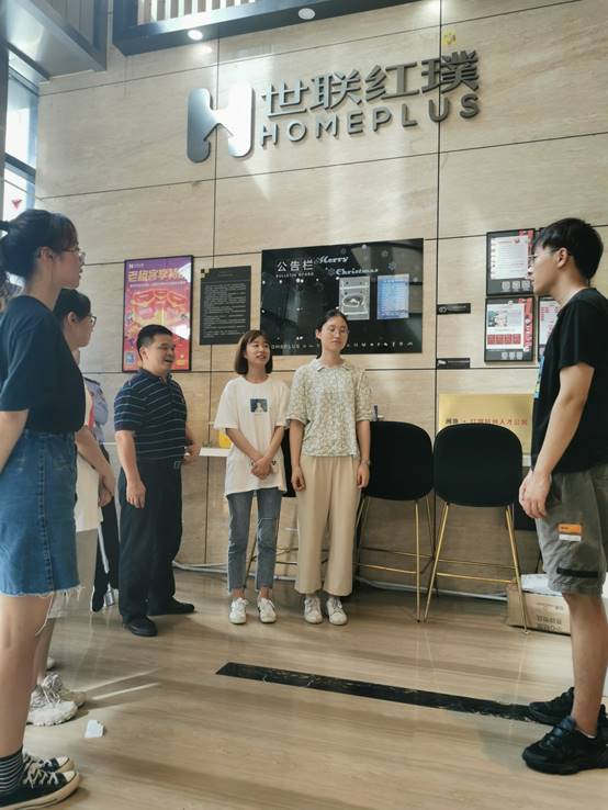 一群人站在室内描述已自动生成 一群人站在室内描述已自动生成